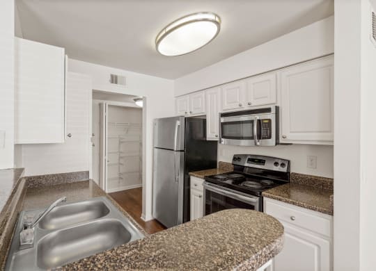 a kitchen with granite countertops and white cabinetsat Stonebriar Woods Apartments, Kansas, 66213