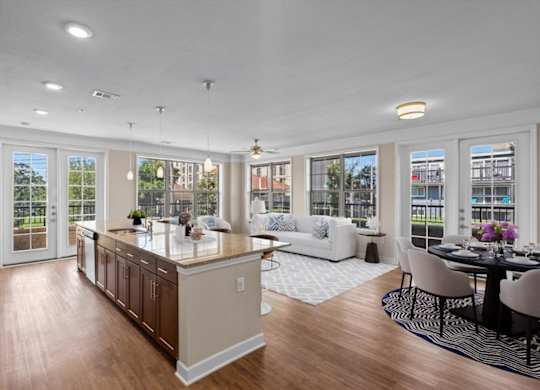 a kitchen with a center island next to a living room with a couch and a table at The Dorset, Kansas City, Missouri