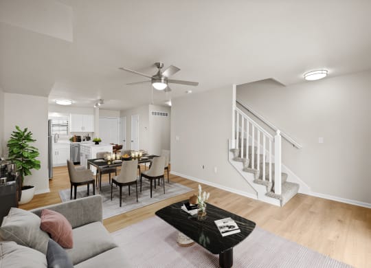 the living room and dining area of a home with a staircase and a dining table