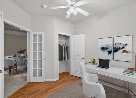 A private study with hardwood floors, a ceiling fan, french doors, and a clothes closet.