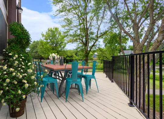 a patio with a table and chairs on a wooden deckat Millcreek Woods Apartments, Kansas, 66061