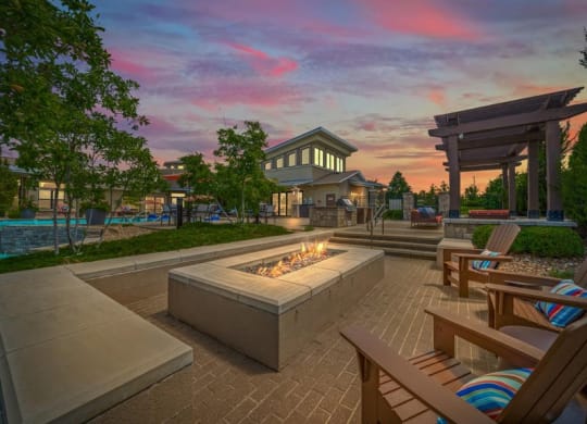 a patio with chairs and a fire pit