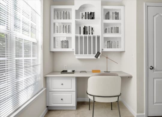 a home office with a white desk and chair and a window