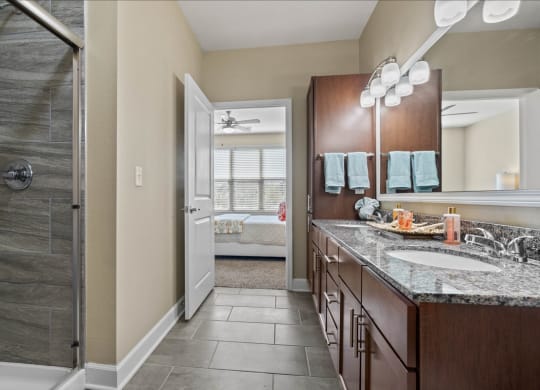 a bathroom with a shower and a sink and a mirror at The Residences at Bluhawk Apartments, Kansas, 66085