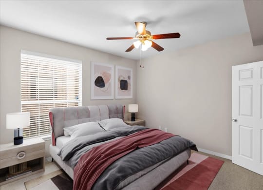 a bedroom with a bed and a ceiling fan at The Clairborne Apartment Homes, Grand Prairie, Texas