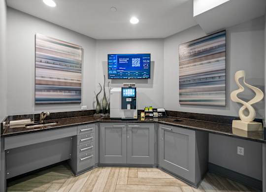 A modern kitchen with a wooden floor and grey cabinets.