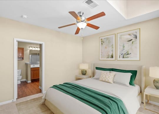 A bedroom with a ceiling fan and attached bathroom