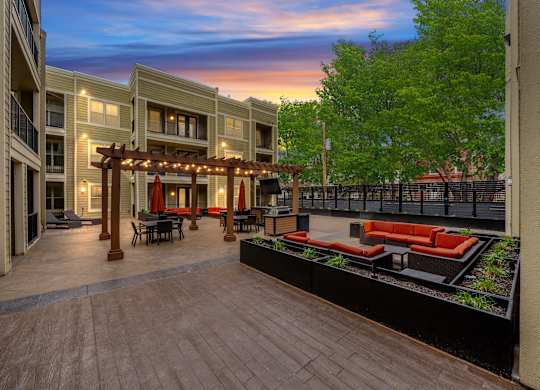 Spacious courtyard at West 39th Street Apartments with multiple seating areas, pergola, and outdoor TV at West 39th Street Apartments, Kansas City, 64111