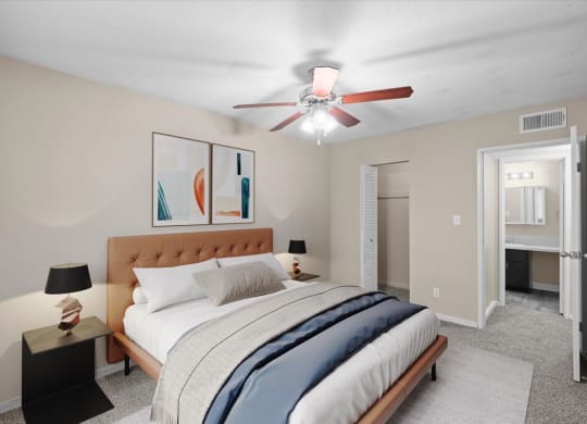 A bedroom with a ceiling fan and attached master bathroom.