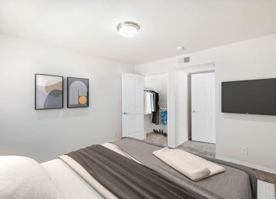 a bedroom with a large bed and a television on the wall at Stonebriar Woods, Overland Park