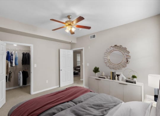 a bedroom with a large bed and a ceiling fan at The Clairborne Apartment Homes, Texas