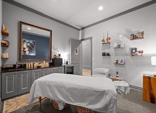 A bedroom with a bed, a nightstand, and a painting on the wall.