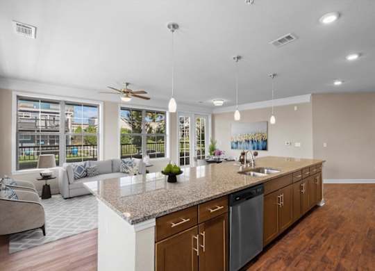 a kitchen with a large island and a living room in the background at The Dorset, Kansas City, 64112