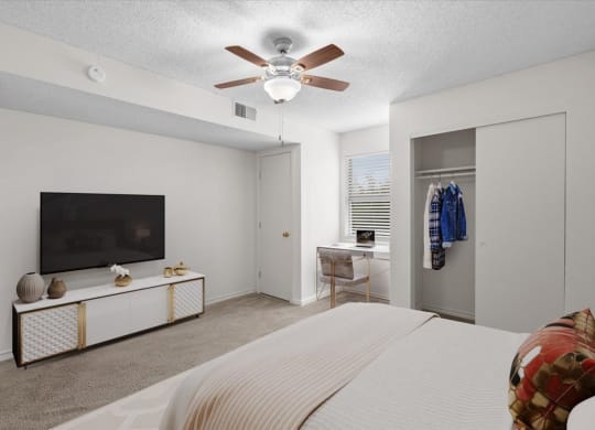 a bedroom with a large bed and a ceiling fan at Wind River Lodge, Lenexa