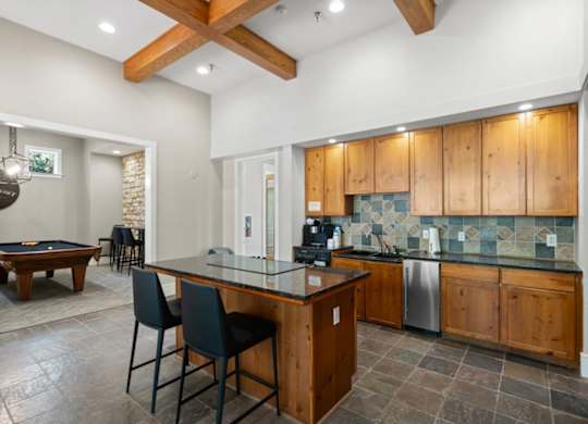A kitchen with wooden cabinets and a glass island. at Stonepost Lakeside Apartment Homes, Olathe