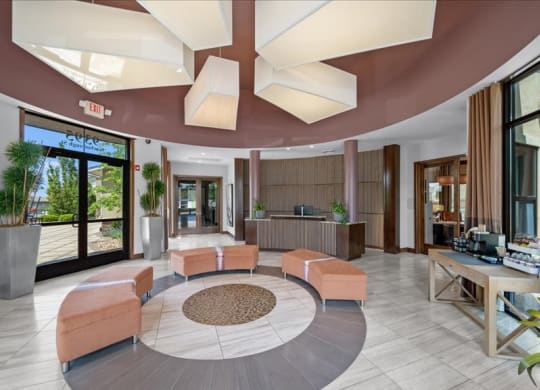 a lobby of a hotel with couches and a reception desk