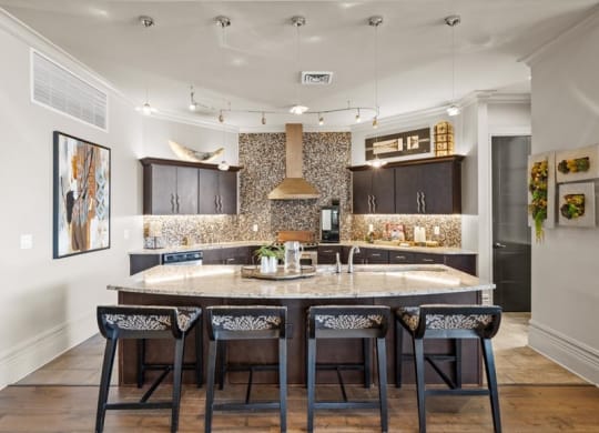 a kitchen with a large island with four chairs