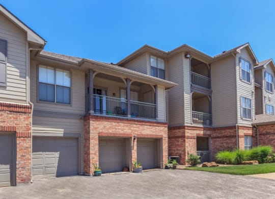 The exterior of an apartment building with balconies and attached garages.