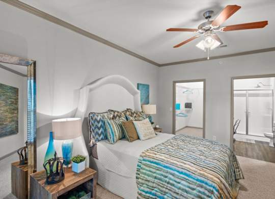 a bedroom with a bed and a ceiling fan at Stonepost Crossing Apartments, Overland Park