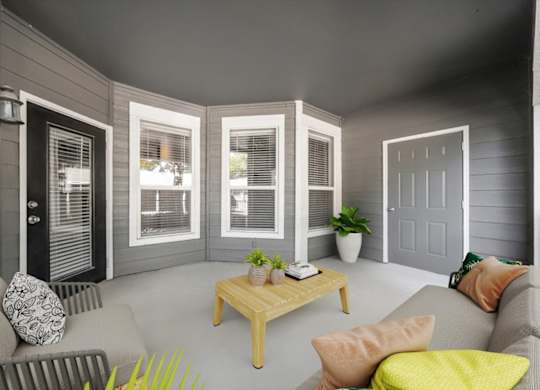 A living room with a grey couch, a wooden coffee table, and a grey wall. at Somerset Oaks Apartment Homes, Olathe