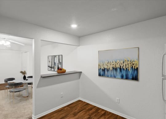 an empty room with a dining room table and a painting on the wallat Millcreek Woods Apartments, Olathe