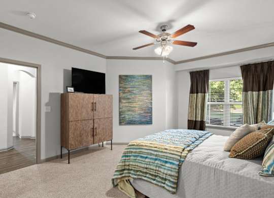 a bedroom with a bed and a ceiling fan at Stonepost Crossing Apartments, Overland Park, KS