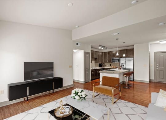 a living room with a fireplace and a kitchen in the background