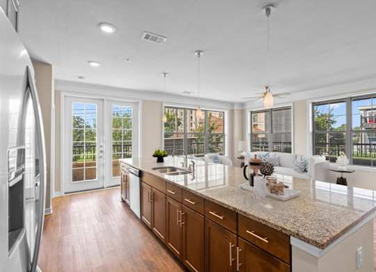 a kitchen with a large island next to a living room at The Dorset, Kansas City, MO