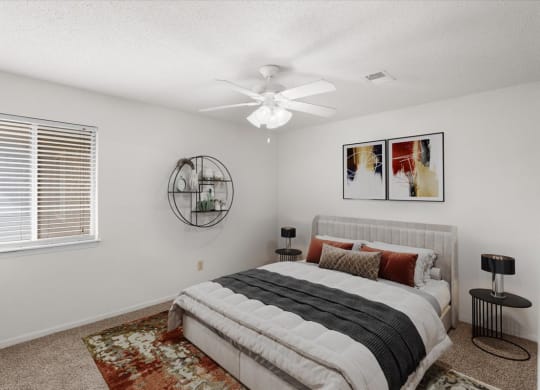 a bedroom with a bed and a ceiling fan at Deerfield Apartments, Olathe, KS