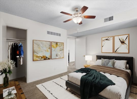 an empty bedroom with a bed and a ceiling fan at Wind River Lodge, Lenexa