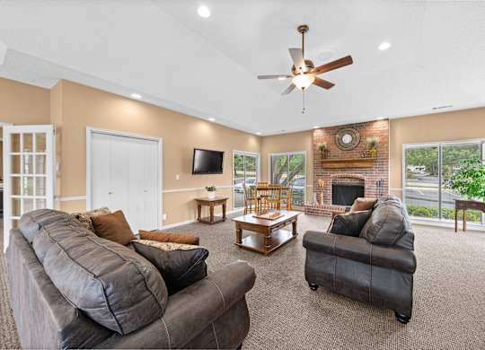 A living room with a grey couch and a fireplace.