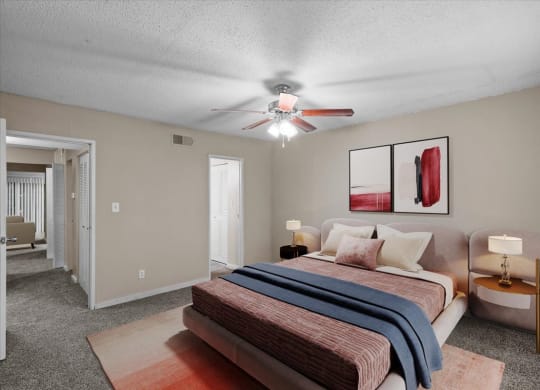 A bedroom with a ceiling fan and attached master bathroom.