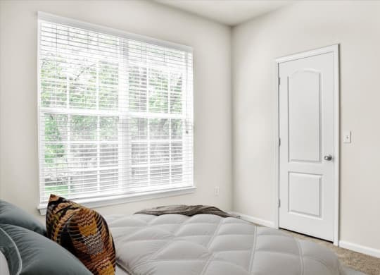 a bedroom with a bed and a large window