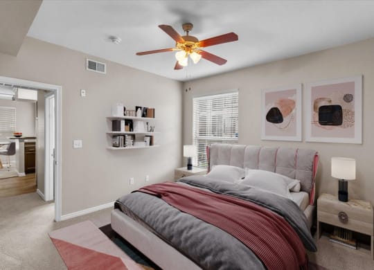 a bedroom with a bed and a ceiling fan at The Clairborne Apartment Homes, Grand Prairie, Texas