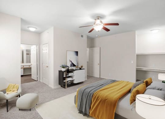 A large master bedroom with a ceiling fan, built-in shelving, bedroom closet and attached master bathroom.
