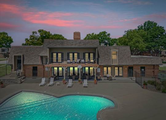 A large house with a pool in front of it.