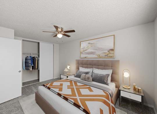 A bedroom with a bed, a ceiling fan, and a painting on the wall.