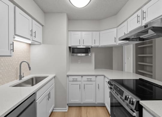 an empty kitchen with white cabinets and a sink at Highland Park Apartment Homes, Kansas, 66214