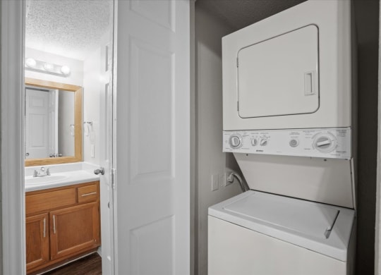 a white washer and dryer in a bathroom at Creekview Apartment Homes, Texas, 75254
