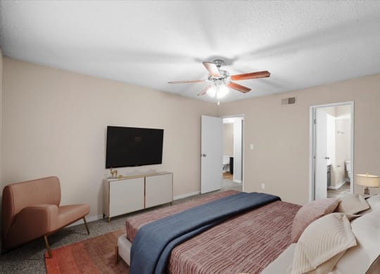 A bedroom with a ceiling fan and attached master bathroom.