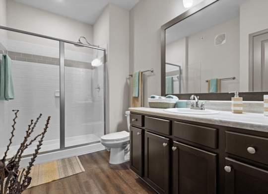 a bathroom with a toilet sink and shower at Stonepost Crossing Apartments, Overland Park, Kansas