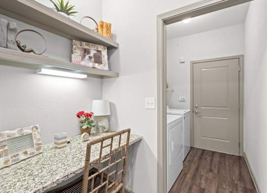 a dining room with a table and chairs and a laundry room in the background at Stonepost Crossing Apartments, Kansas, 66213