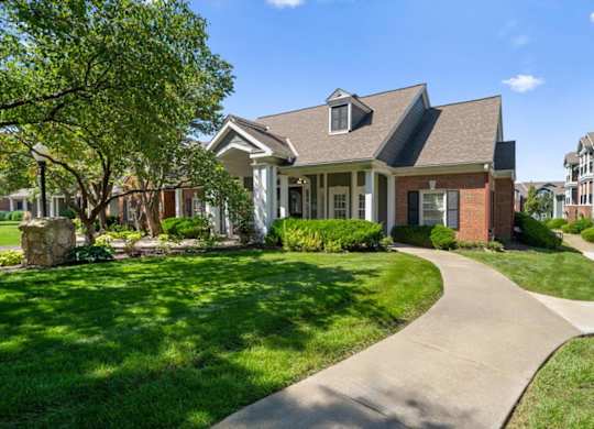 A house with a well-manicured lawn and a stone pathway leading to the front door. at Somerset Oaks Apartment Homes, Kansas