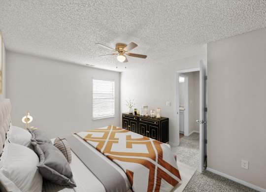 A bedroom with a bed, nightstand, and a ceiling fan.