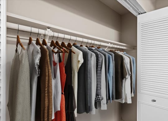 A bedroom closet with a clothing rack and french doors.
