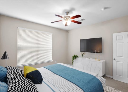 a bedroom with a bed and a ceiling fan at The Clairborne Apartment Homes, Grand Prairie, Texas