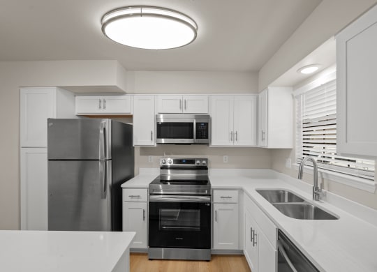 a kitchen with white cabinets and stainless steel appliances