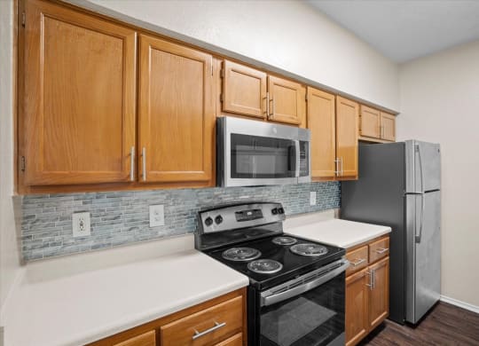 a kitchen with a stove refrigerator and microwave at Creekview Apartment Homes, Dallas, 75254