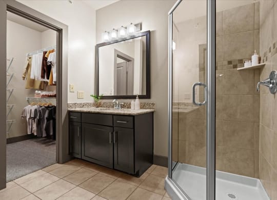 a bathroom with a shower stall sink and mirror