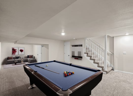 a basement with a pool table and a staircase